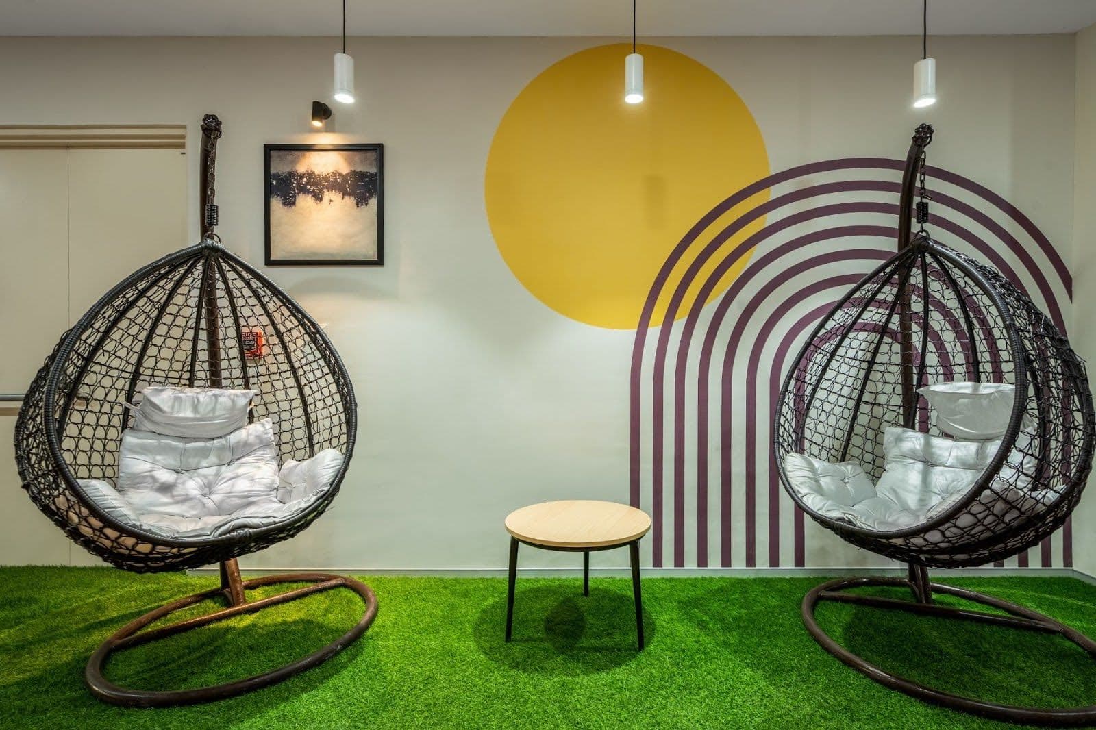 Office relaxation zone with swing chairs and green turf for biophilic comfort